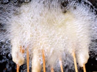 4、鸡肉串串香,锅中倒入油加热至七成热放入鸡肉串串中火炸起来