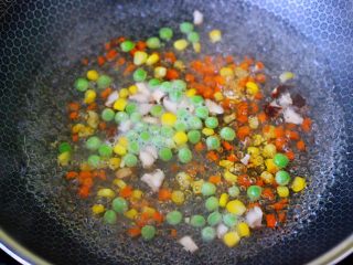 5、海虾时蔬双米粥（宝宝辅食）,把切丁的胡萝卜和香菇，新鲜玉米粒和青豆，放入锅中，倒入适量清水，加入少许盐烧开，焯1分钟后捞出沥干水分。