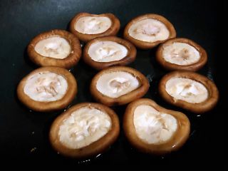 2、蒜蓉蚝油香菇,锅中倒入底油加热放入香菇中小火煎起来