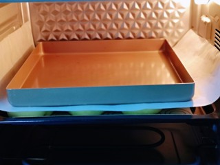 12、蜜豆喜饼～香甜松软,发酵好的喜饼胚是原来两倍大，盖上一张油纸，再放上一个烤盘。