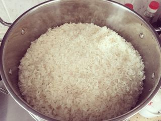 2、米酒????????酒糟,将糯米泡7-8个小时。滤干后放入蒸锅内。稍微铺紧实平点哟????。大火蒸30分钟。开盖拿筷子偷偷尝尝熟没熟。