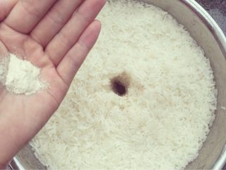 7、米酒????????酒糟,拌匀后，铺成图中的样子，记得要摁实摁平，更要记得中间留个从底部上来的洞洞。小二，表面来点甜酒曲，均匀撒在摁好的糯米表面上。记得中间洞里也要撒上噢。