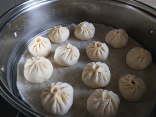 11、儿童小笼包  新文美食,蒸锅加入适量水，屉布洗湿透了铺上，摆放包子，二次发酵20分钟。