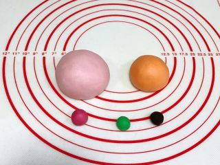 7、吉祥如意小猪馒头,面团分别加入各颜色色素揉匀,110克加少许粉色色素,3克面团加入粉色色素(要比110克粉色面团深些),65克面团加入橙色色素,1克加入绿色色素,1克加入竹炭粉。