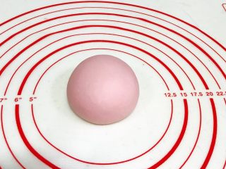 8、吉祥如意小猪馒头,把淡粉色的面团揉匀滚圆,轻轻按扁点。