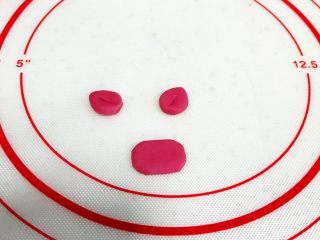 9、吉祥如意小猪馒头,把3克玫红色的小面团如图做成小猪的鼻子和耳朵。