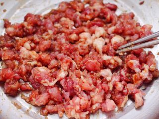 8、西葫芦猪肉发面包,把猪肉馅和所有的调料混合，顺时针方向搅拌上劲。