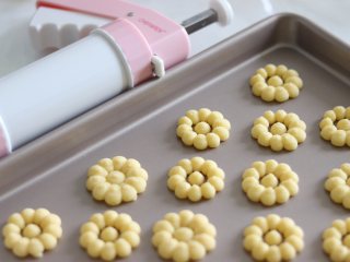 9、醇香酥脆的曲奇饼干（曲奇枪版），冬日温暖小零食,挤到烤盘上即可，这里需要注意一下，尽量直接挤到烤盘上，如果垫油纸的话，会导致曲奇花离模失败，油布的话相对好些，如果油布也不好操作的话，就尽量挤到烤盘上吧。