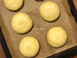 7、无油陈皮红豆馅小面包,大概40～60分钟后，面团肉眼可见膨胀了，用手指轻轻按压，指印慢慢恢复一部分，这时可以预热烤箱了。还可以在面团表面喷一点点水，撒上芝麻。