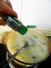 12、咸肉皮蛋粥,再淋入几滴色拉油继续熬煮10分钟。要不停的搅拌。