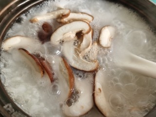 14、香菇滑鸡粥,先加入香菇片煮两分钟。