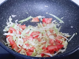 12、营养健康早餐  卷心菜番茄全麦鱼面,起油锅，加入切好的番茄卷心菜编炒。