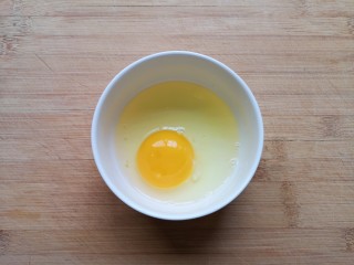 5、鸡蛋小米粥,鸡蛋磕入碗里。