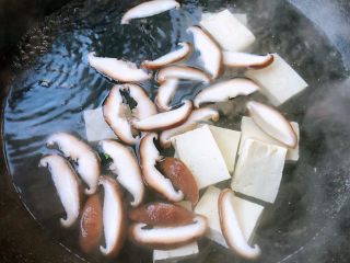 3、肥羊海虾时蔬面,下入切好的香菇片和豆腐片大火煮起来