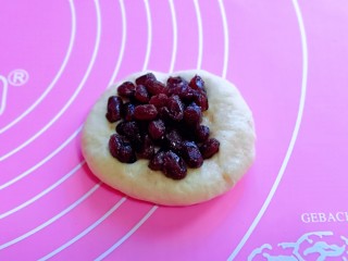 9、超级松软零失败的全麦蜜豆小餐包,取一块面团，用擀面杖擀开，加入蜜豆馅，如包包子的手法包起来，收口捏紧。