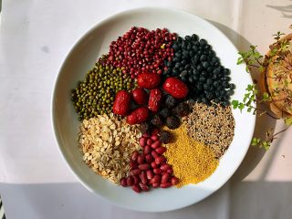 1、腊八粥,准备好所有食材。家里有这么多就顺手拿来做了，没有额外去买，数了下九种，凑了个吉利数，长长久久，腊八粥不一定非要是八种，大家可以灵活应用。加桂圆和红枣是为了让粥的口感更美味，也可以加葡萄干进去。