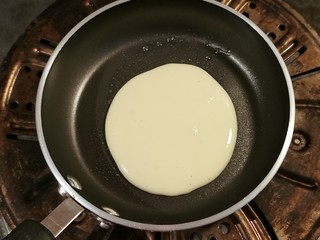 9、酸奶鸡蛋饼,用勺子倒入面糊  从中间缓慢倒入 自成圆形