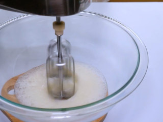 3、巧克力马卡龙,蛋清中加入几滴柠檬汁,将电动打蛋器开启低速,搅打至蛋清出现大鱼眼泡后加入1/3的细砂糖。