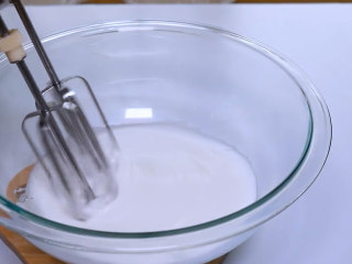 5、巧克力马卡龙,蛋清搅打细腻后,第二次加入细砂糖,继续中速搅打至蛋清出现纹路。