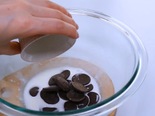 15、巧克力马卡龙,准备马卡龙夹层。30g热牛奶中加入50g巧克力,搅拌至巧克力完全融化。