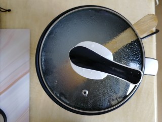 7、番茄丝瓜补钙粥,再次煮开后,关小火慢煮。放入铲子(防止煮沸汤溢出来),盖上锅盖,煮10分钟
