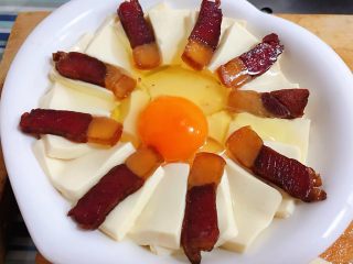 4、腊肉蒸豆腐卧蛋,中间打入一个鸡蛋