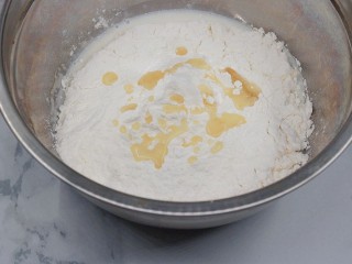 1、云朵馒头,依序加入牛奶、酵母粉（撒开）、细砂糖，再加入中筋面粉和花生油