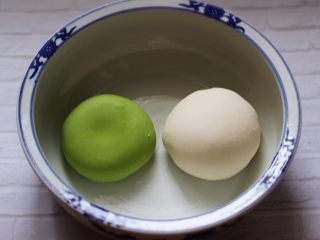 5、翡翠白玉生煎包,和好的菠菜面团放入盆中，同样的方法把剩下的100克面粉和50克清水，1克酵母和10克甘汁园双碳白砂糖	加入面包机里和成白色的面团，把两块面团分别揉圆后进行醒发。