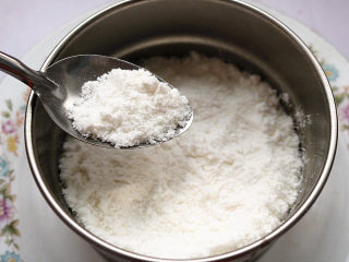 8、红豆蒸松糕,抖动勺子将米粉撒在模具上，铺满一层。注意这一步不能用勺子将米粉压实，如果压实，出来的口感就不是松松软软的，是比较扎实的口感。