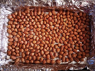 2、美味花生糖,花生平铺在烤盘中，放入烤箱中层上下火180度烤12分钟