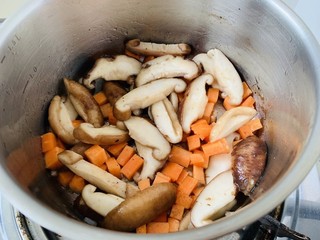 5、香菇滑鸡粥,锅中放少许油,把香菇,胡萝卜丁放进去,爆香。