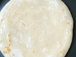 8、千层油饼,提前热锅后抹少许油(油一定不要放多，放多了可以用厨房纸吸出来)，放入饼胚，先快去烙大约半分钟至底部稍微定型赶紧翻面烙至稍微上色，锁住饼内水份。(第一次翻面不能时间太长，以免靠干水份，使烙出的饼干硬)