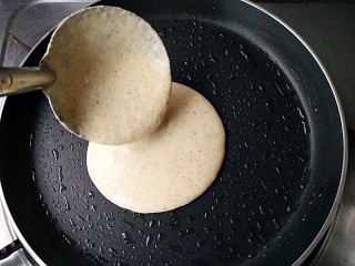 4、杂粮煎饼,舀一勺面糊倒入锅中。