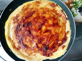 8、杂粮煎饼,然后翻面，在另一面均匀涂上甜面酱或者辣酱（任何各种自己喜欢的酱都可以）。