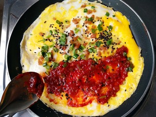 12、杂粮煎饼,摊煎饼，打鸡蛋，撒榨菜碎，香菜，香葱，黑芝麻，不翻转，涂辣酱。