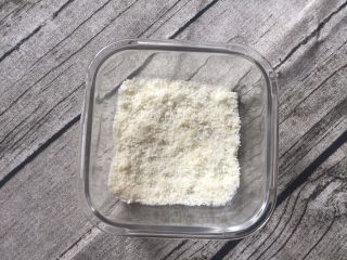 7、火龙果椰蓉奶冻,将一半椰蓉先平铺倒进容器底层待用