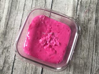 13、火龙果椰蓉奶冻,将翻炒完成的火龙果糊倒入事先铺好椰蓉的容器中