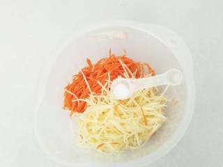 2、黄金田园菜饼,胡萝卜和土豆擦成细丝，放入2克盐。