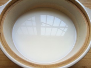 3、奶香南瓜粥,纯净水和牛奶一起放进砂锅烧开。