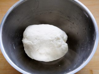 4、经典版蛋黄酥,用手把面初步揉成团，由于水油皮的制作过程中除了加水，后边还要加黄油，所以加水的量不能过多，不然后边再揉进去黄油的话，面团会过软，不利于后边的擀卷等操作，当然根据各家平时用面粉的不同，可以加减10g水略作调整，此时面团的手感应该是有些硬。
