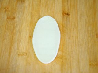 26、经典版蛋黄酥,按扁后擀成牛舌状，长度约10-12cm就足够了，并不是擀的越长酥皮的层次就越多，理论上是卷起来的层数越多，酥皮的层次就越多，但实际上擀的很长的话，酥皮就会很薄，然后多次擀卷后，油酥和油皮就粘到一起了，这就是混酥了，这样的酥皮经过烤制也是无法起酥分层的，所以在这一步千万不要贪长，由于酥皮的整个擀卷过程要“两卷一折三擀”，在这一步擀10cm已经足够了。