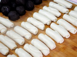 29、经典版蛋黄酥,24个酥皮的第一次擀卷依次完成，虽然说酥皮第一次擀卷完成后要醒5-10分钟，目的还是为了让面团松弛，方便下次擀卷，不然松弛不到位擀开了还会收缩。但是，我们制作的时候采用的是小包酥的方式，也就是一个一个的包、擀、卷，第24个卷好的时候，第1个卷好的酥皮团也已经醒好了，在实际操作中这一过程是连续的。前边卷好了醒着，最后卷好了，前边的也醒好了。