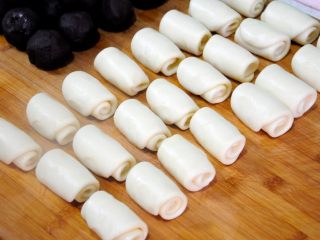 33、经典版蛋黄酥,完成二次擀卷的酥皮团。同步骤29，第24个酥皮面团卷好的时候，第1个卷好的酥皮团也已经醒好了，接着进行下一步的操作就行。