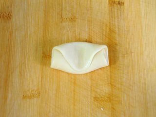 34、经典版蛋黄酥,取一个完成二次擀卷的酥皮面团，在中间用手指按一下。