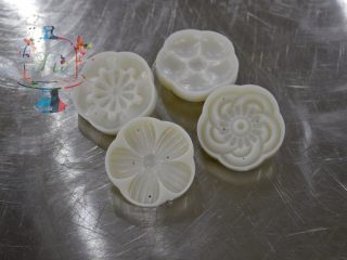 1、好看好玩又好做的颜值担当——桃山皮月饼,这个是花片,我们要先单独取出来,撒上面粉之后再磕掉多余的面粉。花片上不能沾太多多余的面粉。否则烤好后会干裂