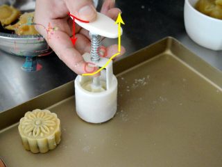 7、好看好玩又好做的颜值担当——桃山皮月饼,准备一个不粘烤盘,如果没有不站烤盘,可以铺一张锡纸,亚光面向上。去年月饼的实操课上,我发现有的同学不会使用月饼模。找了张去年的图给大家示范