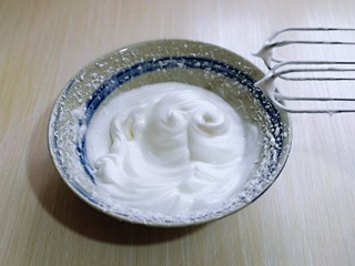 13、无油低脂～奶香松饼,打至湿性发泡时加入最后的三分之一糖，打至蛋白出现细腻的纹路，将电动打蛋器调低速打发一会儿，感觉有些阻力时，就可以停止打发，以免消泡，提起打蛋器有微微的弯勾就可以。