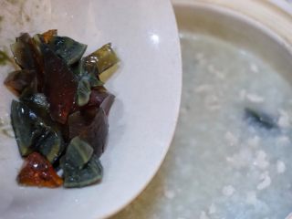11、皮蛋瘦肉粥,加入剩下的一半皮蛋,搅匀,继续煮两分钟,加入少许的盐拌匀,即可关火。