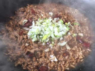 8、营养早餐 肉末雪菜玉米面粥,放入葱花,翻炒均匀,