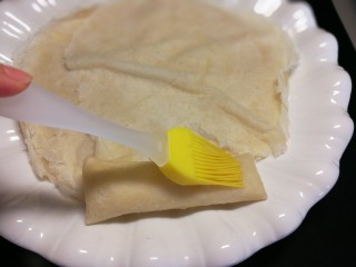 7、香蕉奶酪春卷,春卷皮办好最后尾部可以涂点水方便粘贴牢固。有时不涂也可以，包好后收口处压在下方摆放也可以加固封口。